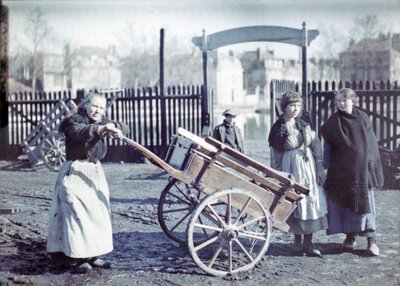 Alte Frau mit einem Karren auf einer schlammigen Straße, mit zwei Mädchen und einem Jungen, Frankreich, ca. 1914-18 von French Photographer